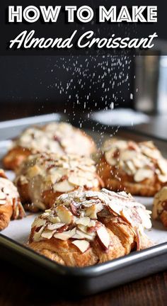almond croissants are being sprinkled with powdered sugar