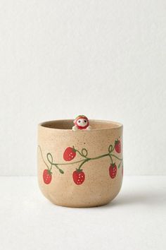 a ceramic cup with a small red bird on it