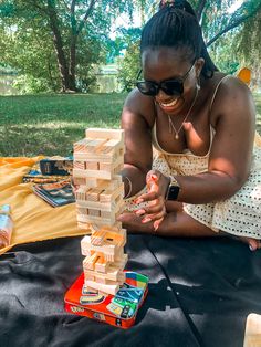 a woman playing with wooden blocks in the park