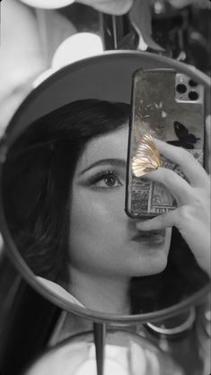 a woman taking a selfie in front of a mirror with her cell phone up to her face