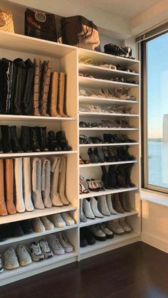 a closet filled with lots of shoes next to a large window overlooking the city skyline