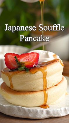 a stack of pancakes sitting on top of a white plate next to a potted plant