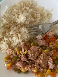 a white plate topped with meat and vegetables next to rice
