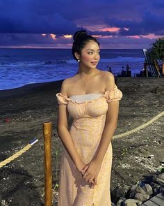 a woman in a dress standing on the beach