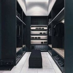 a walk in closet with black walls and white flooring