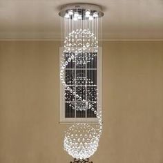 a chandelier hanging from the ceiling in a room with beige walls and flooring