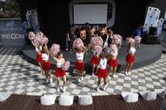 a group of cheerleaders standing on top of a checkered floor