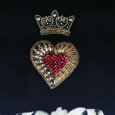 two heart shaped brooches are sitting next to each other on a black surface