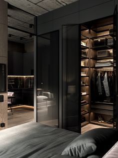 a bedroom with black walls and closets full of clothes in the corner, next to a bed
