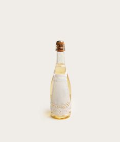 a glass bottle filled with liquid sitting on top of a white tablecloth covered floor