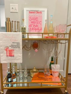 a gold bar cart filled with bottles and glasses