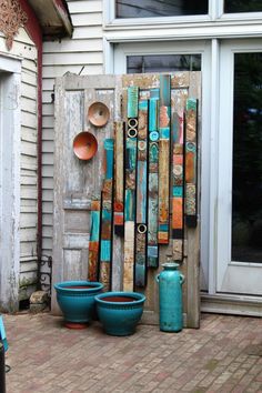 an outdoor area with pots and pans hanging on the wall next to a door