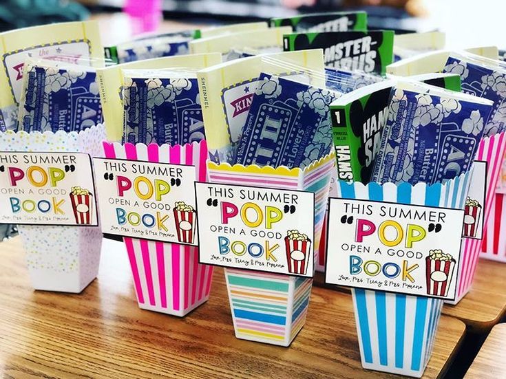 some popcorn boxes are lined up on a table with the words, this summer pop open and book