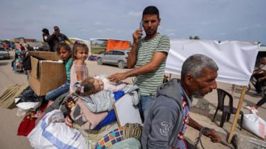 Palestinians fleeing Rafah with their belongings following renewed Israeli strikes in the city in the southern Gaza Strip arrive in Khan Yunis on May 28, 2024
