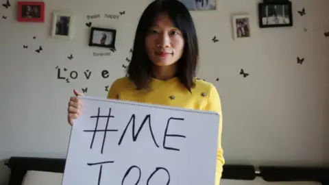 Sophia Huang Xueqin holds a sign reading MeToo