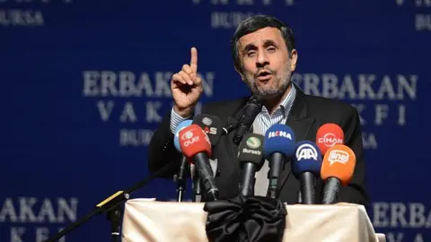 Getty Former Iranian President Mahmoud Ahmadinejad makes a speech in front of a podium in 2015.
