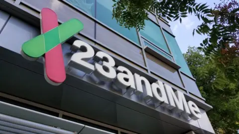 The logo of 23andMe on a sign outside an office building
