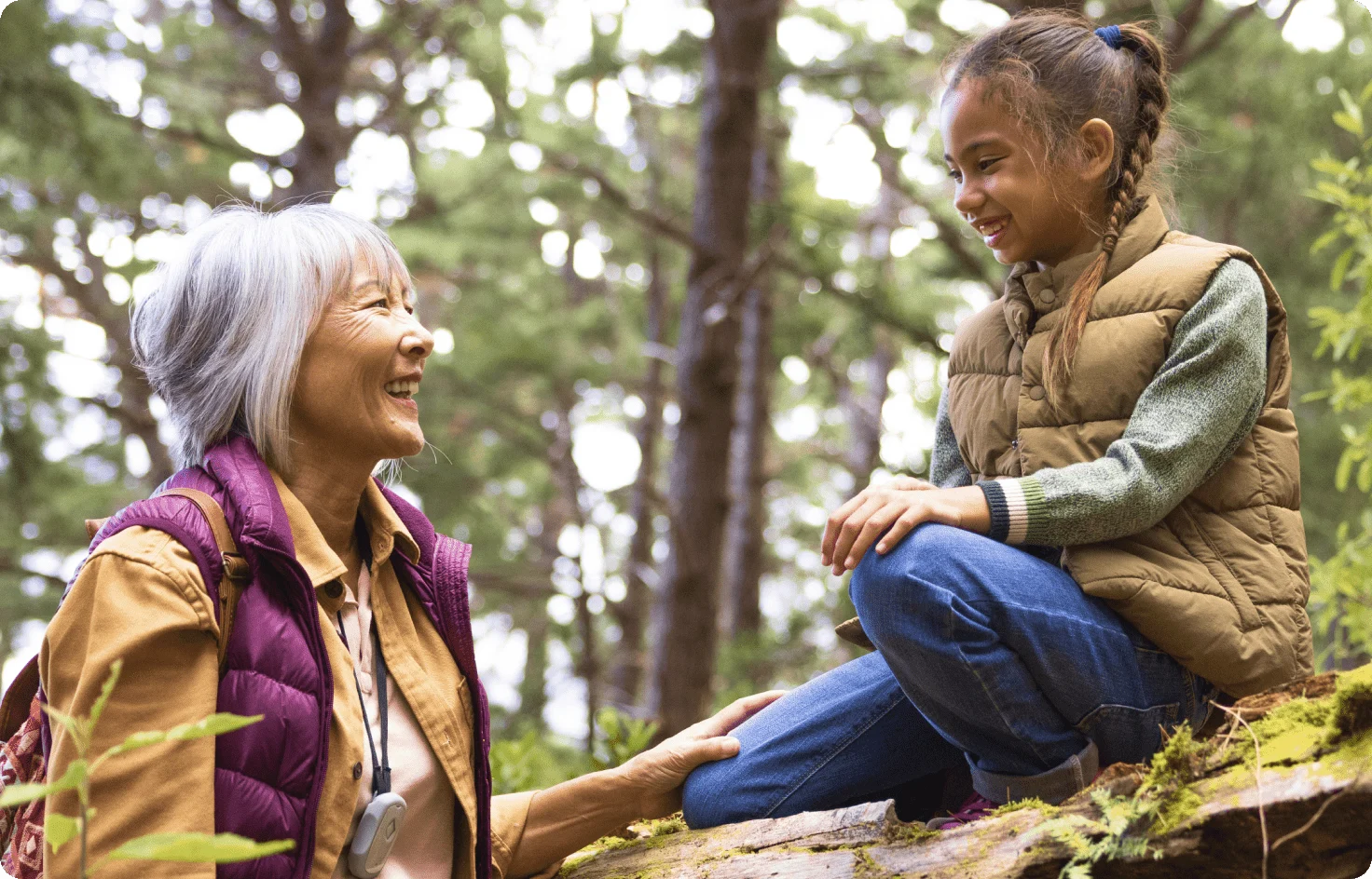 Une dame âgée discutant avec un jeune dans une forêt