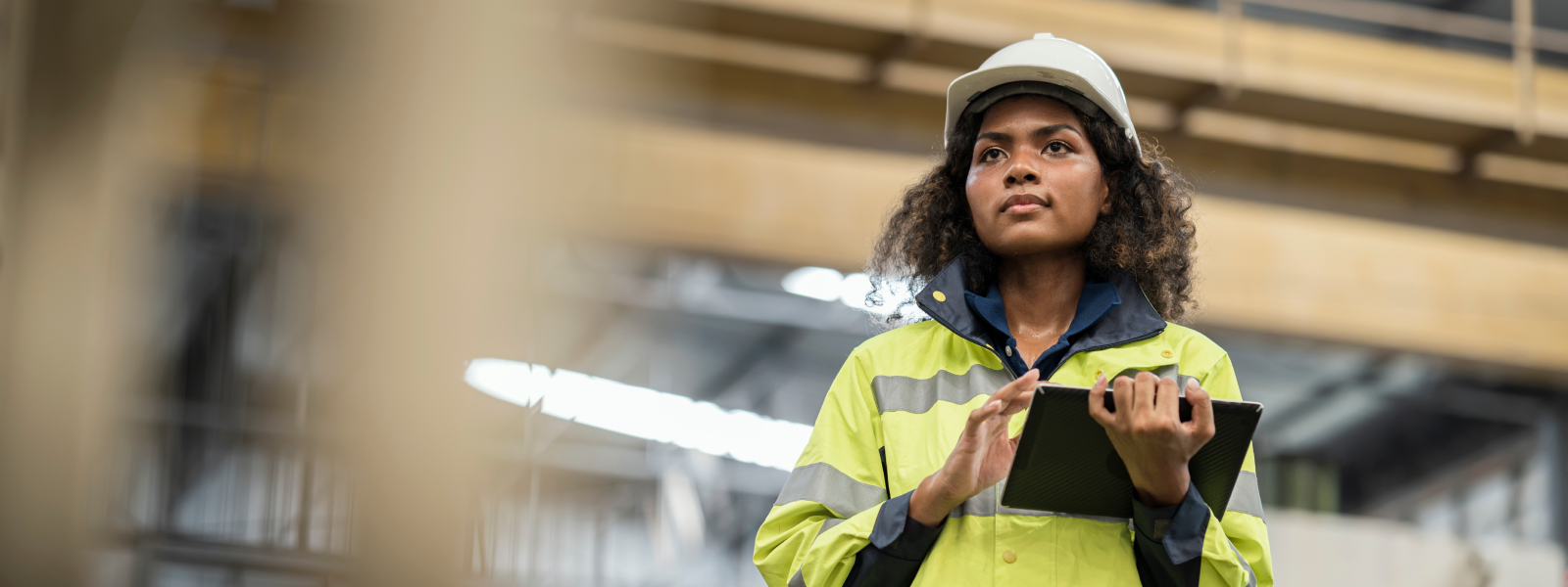 Woman wearing protective workwear using a tablet.