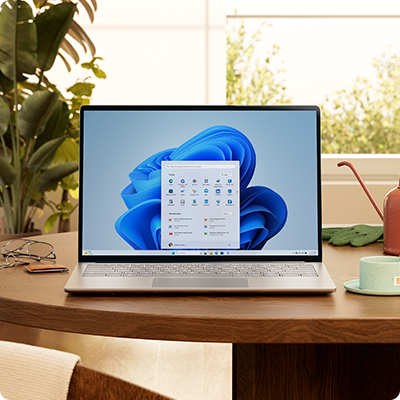 Windows 11 -tietokone, aloitusvalikko ja sininen kukka