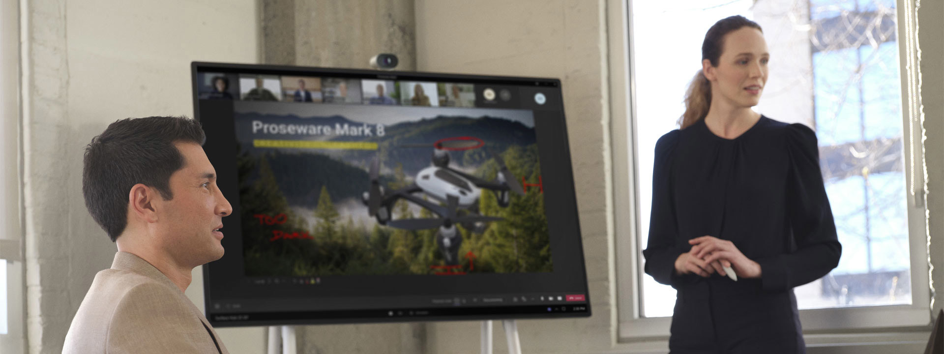 Eine Frau steht vor einem Surface Hub und präsentiert ein PowerPoint-Dokument in einem virtuellen Teams-Anruf
