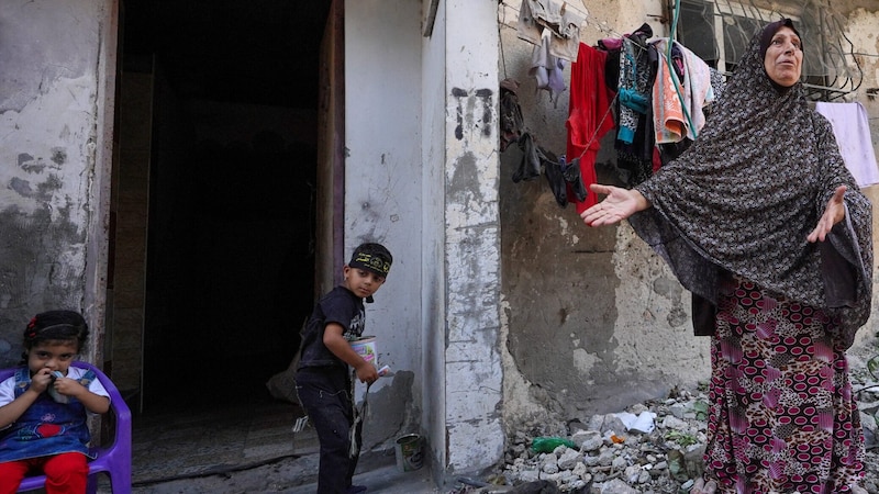 Eine Frau zeigt ihr zerstörtes Haus im Gazastreifen. (Bild: AFP/Bashar Taleb)