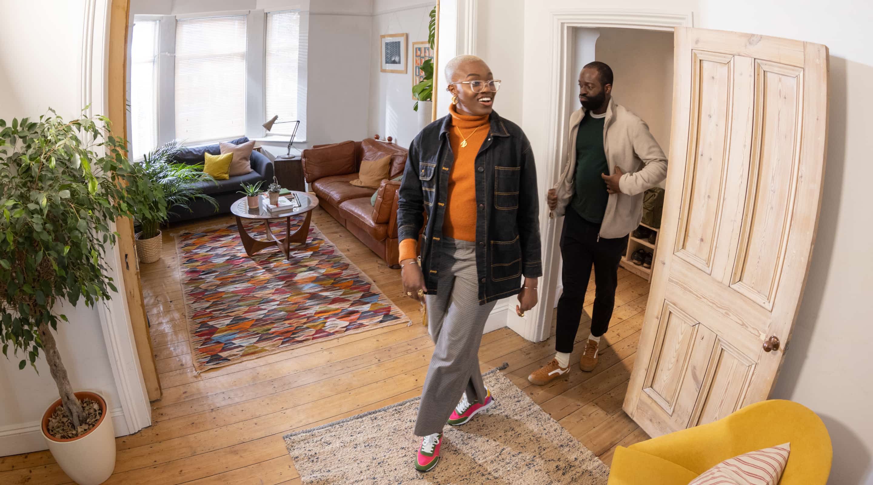 A couple walks into a living room of a residential home.