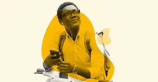 Un home amb ulleres escolta el seu telèfon intel·ligent amb auriculars amb cable.