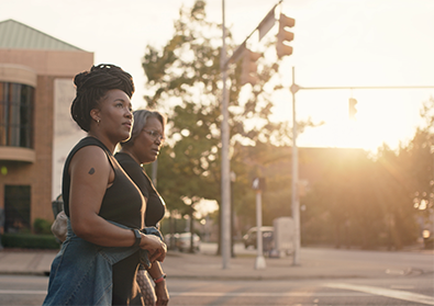 The founders, Ashlee Ammons and Kerry Schrader, walk along a street at sunset.