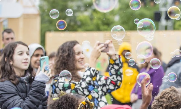 Photo of people blowing bubbles.