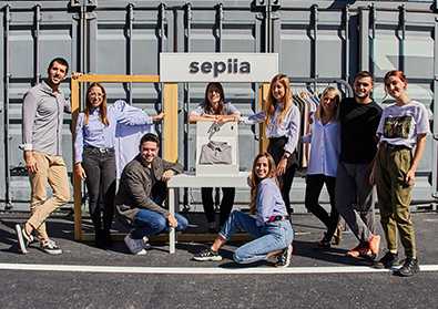 The team of Sepiia pose in front of their sign outside.