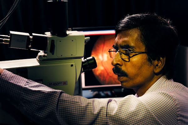 An ophthalmologist looks for damage in a patient's eye scan.