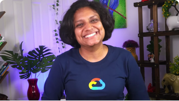 カメラに向かって微笑む Google Cloud の長袖 T シャツを着た女性。