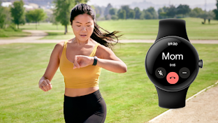 一名身穿運動服的女士在室外公園跑步，左手腕戴著一隻智能手錶。她將左手舉到胸前，低頭看著智能手錶的螢幕。
