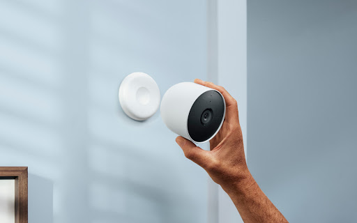 Hand installing Nest Cam on wall.