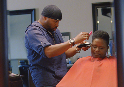 man cutting woman's hair in barber shop