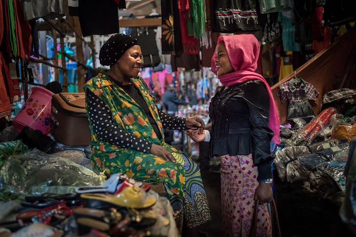 Djamila speaks with another woman at a market in Bukavu.