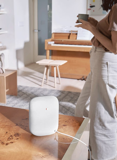 A Nest Audio speaker on a table in a living room