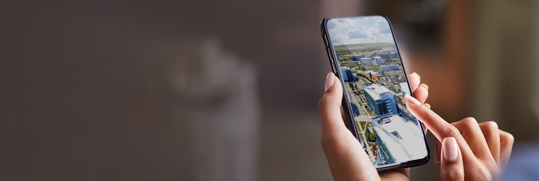 Una mano tiene un telefono con una vista 3D della città