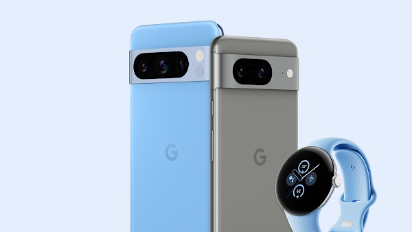 A sky blue Pixel phone stands next to a gray Pixel phone and a sky blue Pixel watch