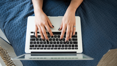 woman typing on a macbook