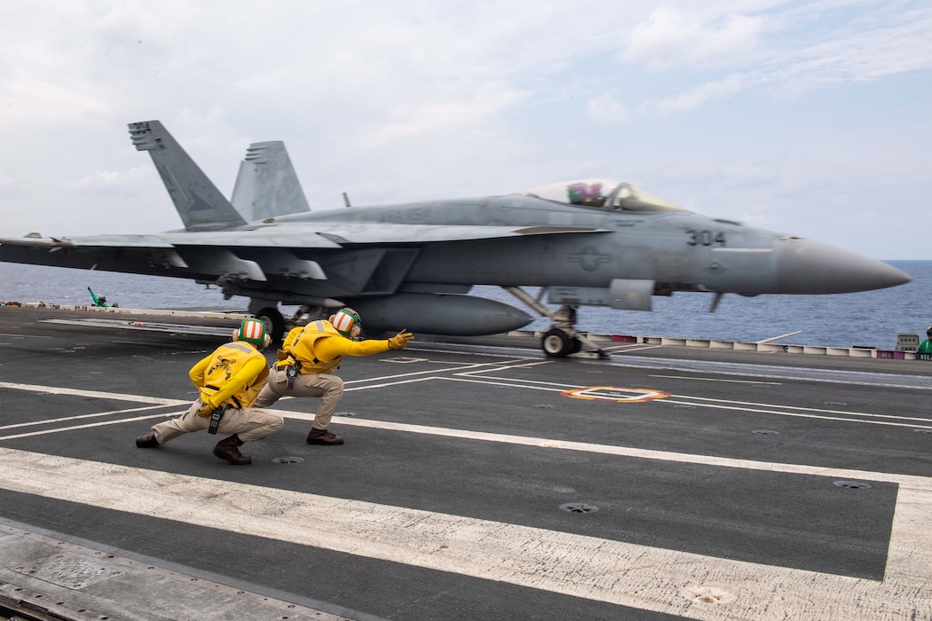 Lt. Brandon White, from Sharpsburg, Kentucky, left, and Lt. Charles Fitzmaurice, from Hutto, Texas, right, signal to launch an F/A-18E Super Hornet, attached to the Eagles of Strike Fighter Squadron (VFA) 115, off the flight deck of the U.S. Navy’s only forward-deployed aircraft carrier, USS Ronald Reagan (CVN 76), in the Philippine Sea, June 3.