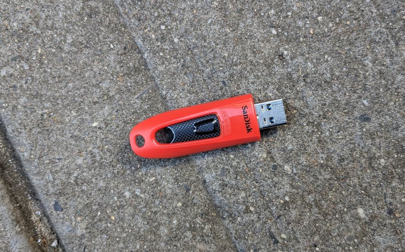 Photo of a SanDisk USB drive on the ground