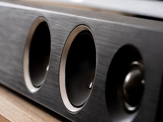 Closeup of black rectangular soundbar with small circular speakers