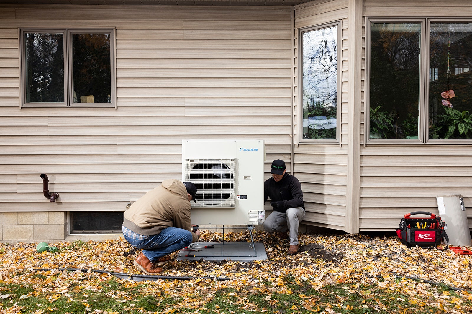 Photo showing Nick Bender right and Thorsten Busch installing a new Daikin heat pump at a home in Shorewood Minn. on...
