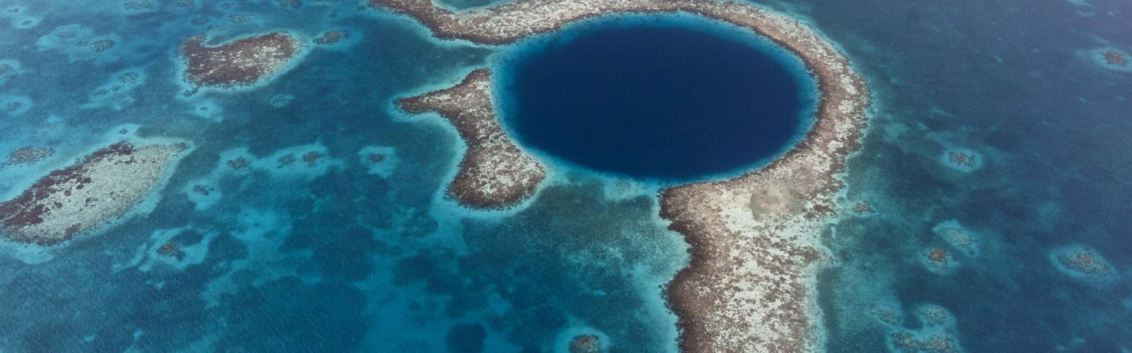 an aerial view of the great blue hole in belize.