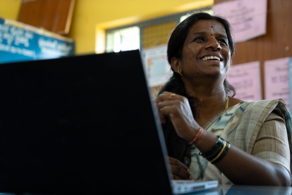 A female teacher at a computer, smiling