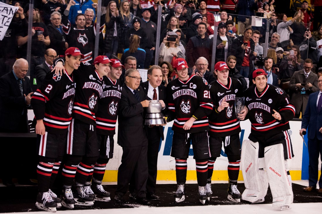 Northeastern hockey players pose with the Beanpot in 2018. 