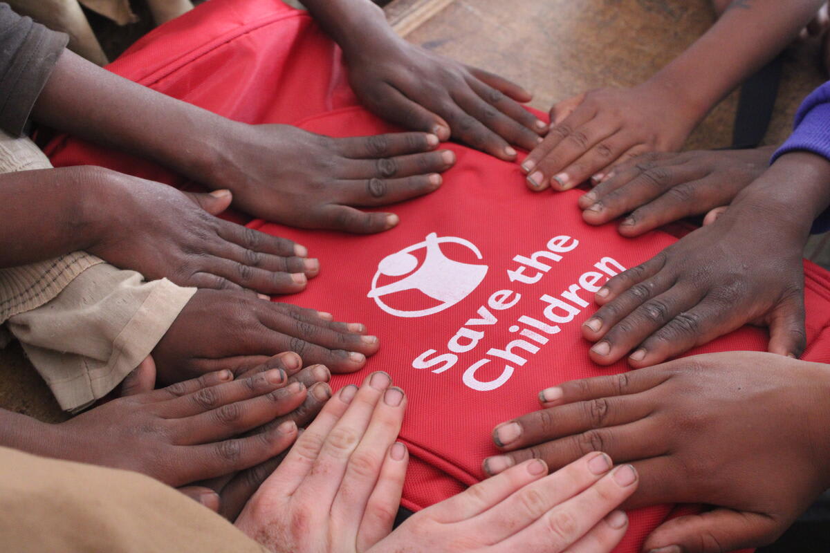 Billede af skolebørns hænder på Red Barnet-taske