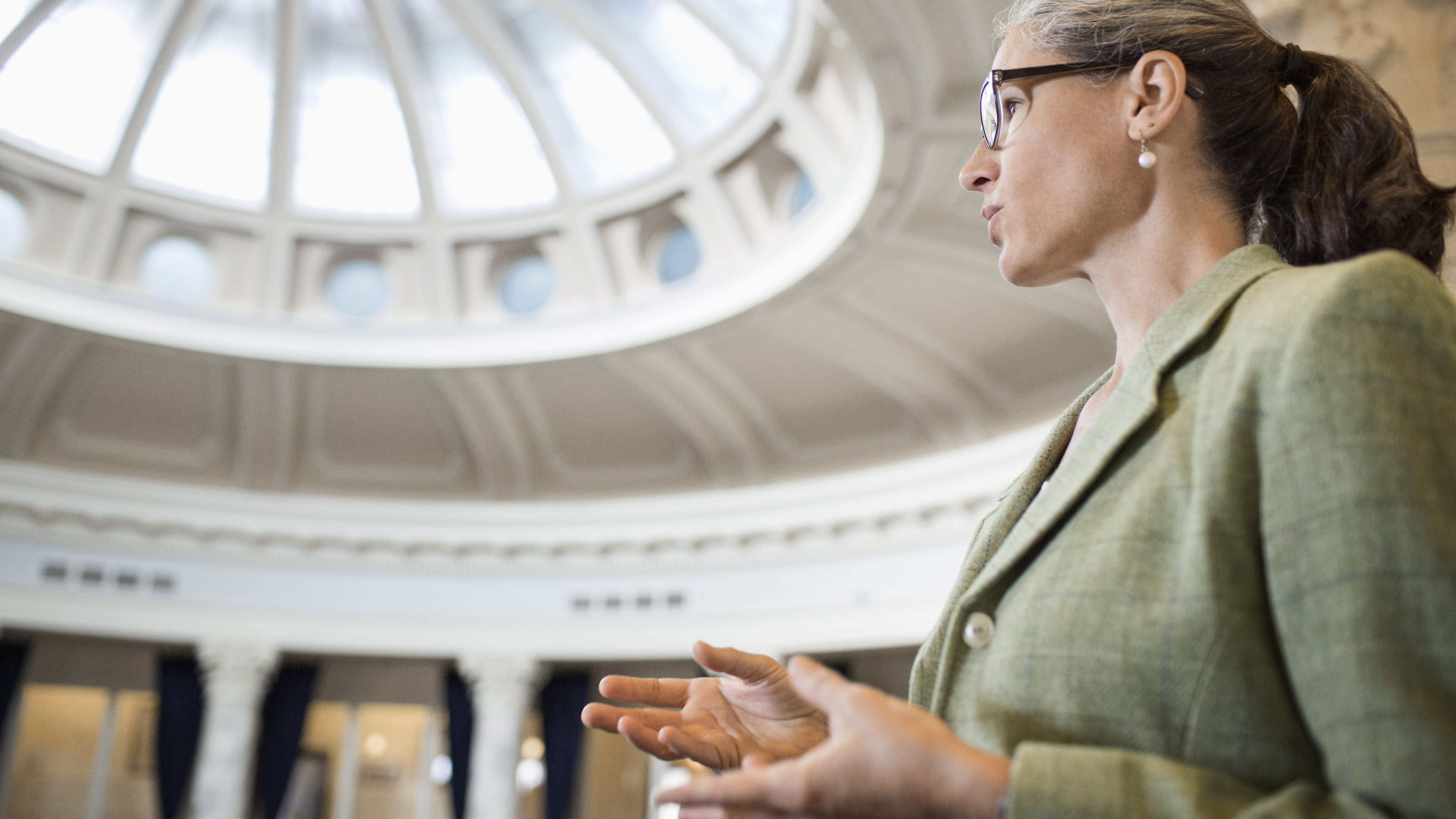 A person speaks in the rotunda of a government building.